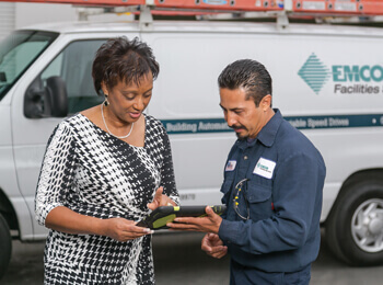 Two employees communicating while looking at a tablet