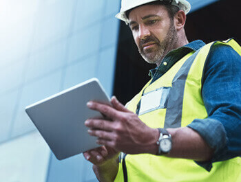 Technical in yellow vest reviewing a table screen